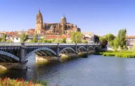 View of bridge across river in Spain with Salamanca cathedral in the background