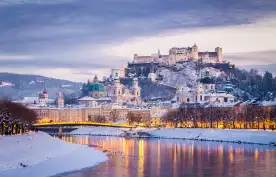Classic view of Salzburg and Festung Hohensalzburg fortress illuminated at Christmas time in Austria