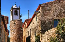 Medieval clock tower amidst a street of Castelo Rodrigo's historical village, Portugal