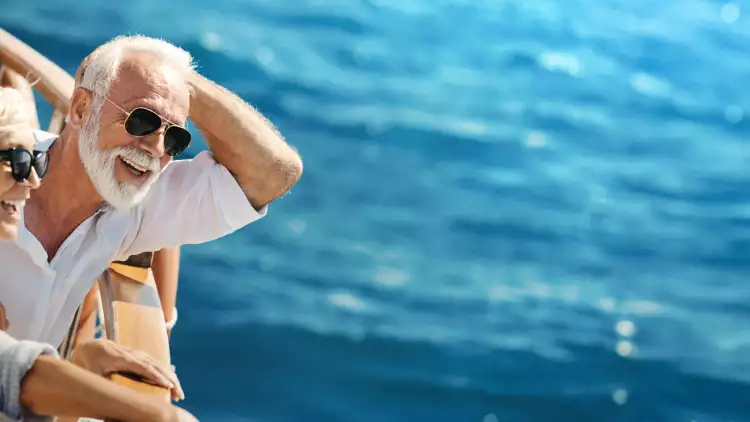 happy couple smiling onboard yacht cruise sailing on beautiful blue waters