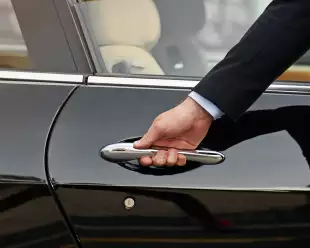 Close-up of concierge opening a private car door