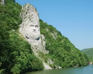 A large rock sculpture of decebalus overlooking the Danube River gorge