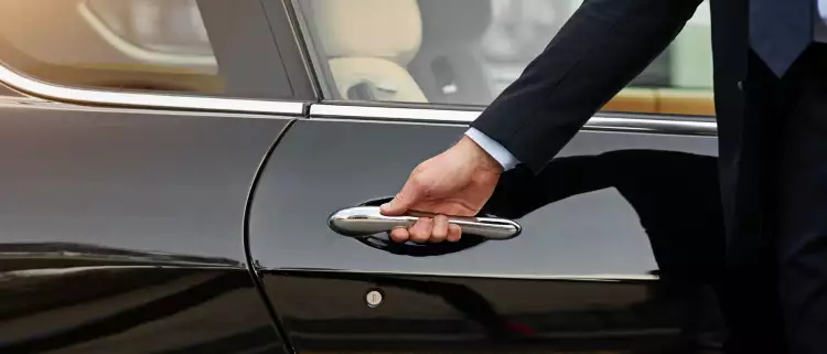 Close-up of concierge opening a private car door