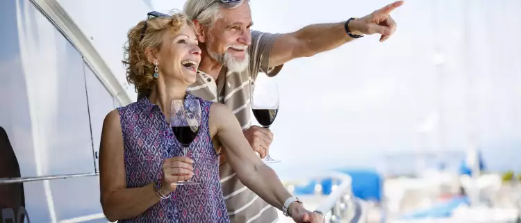 Happy senior couple enjoying wine on yacht