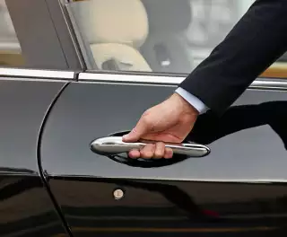 Close-up of concierge opening a private car door
